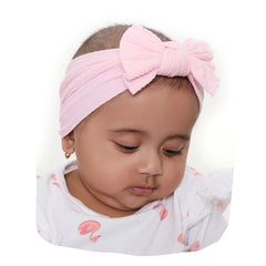 Light pink baby cotton bow headband worn by infant girl, soft and stretchable for newborns, ideal for stylish everyday wear.