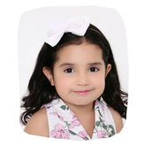 White velvet bow hairband worn by a young girl, perfect for ages 3-10. Soft and stylish accessory for casual or party outfits.