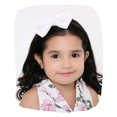 White velvet bow hairband worn by a young girl, perfect for ages 3-10. Soft and stylish accessory for casual or party outfits.