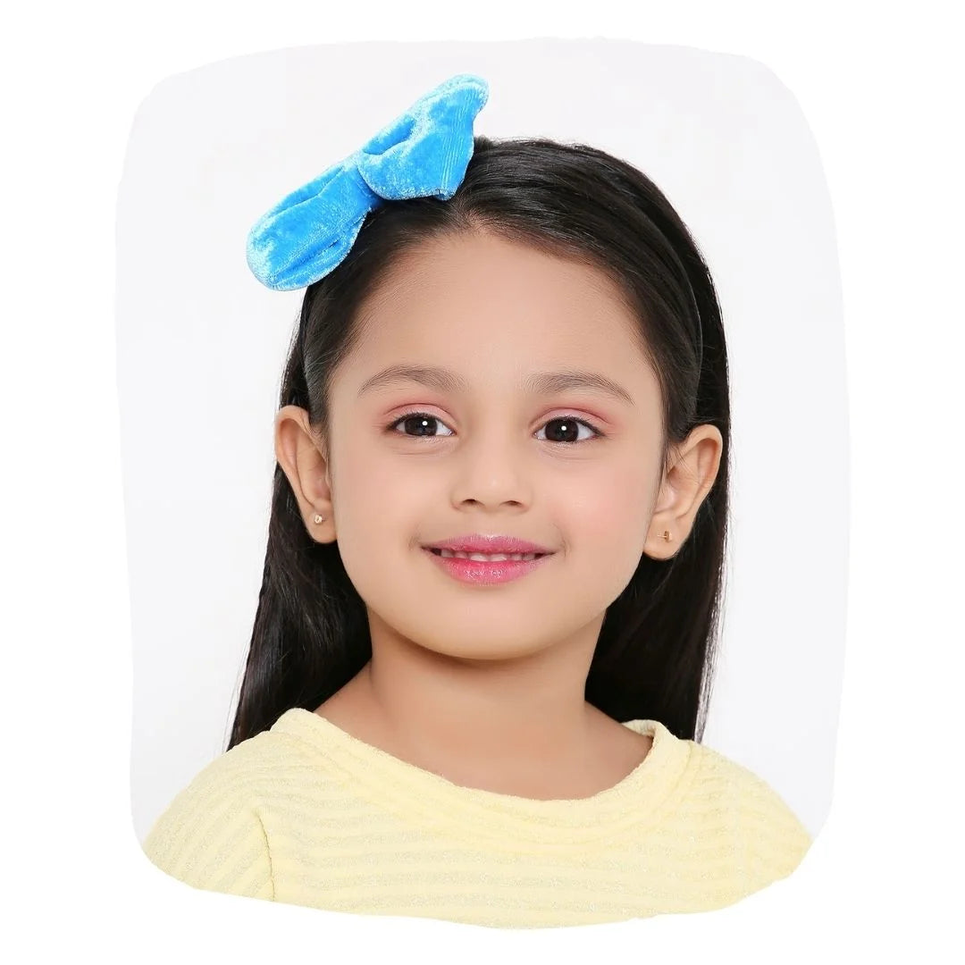 Girl wearing blue velvet bow hairband with soft texture and stylish design, ideal for parties and daily wear.