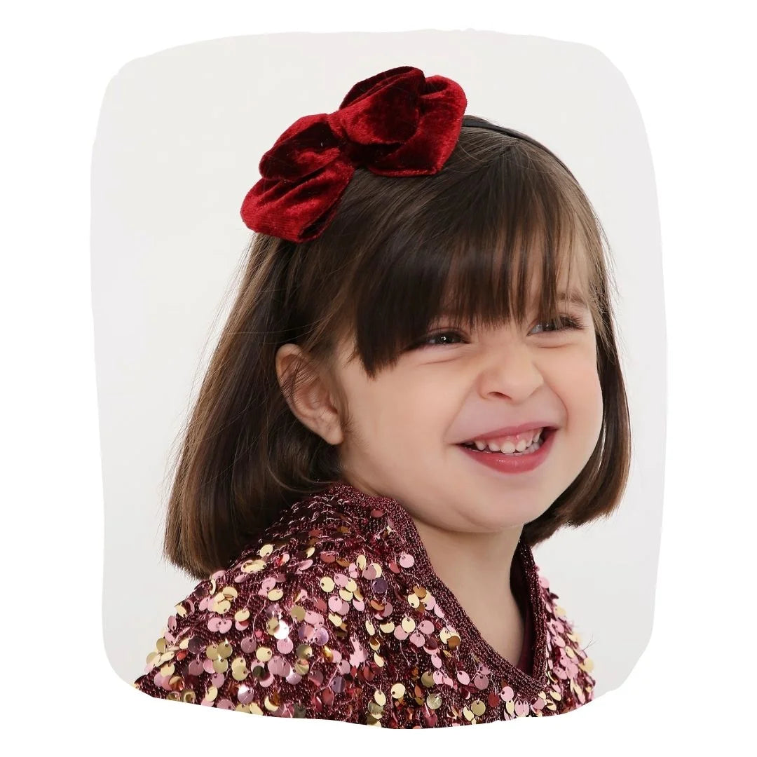 Smiling girl wearing Maroon Velvet Bow Hairband by Arendelle, ideal for ages 3-10. Perfect for parties, daily wear, and gifting.