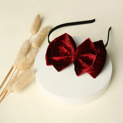 Maroon Velvet Double Layered Bow Hairband displayed on white platform with dried florals, stylish accessory for girls by Arendelle.