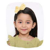 Beige velvet hairband with big bow worn by a smiling girl, ideal for kids' fashion and daily wear. Soft, stylish fit for ages 3-10.