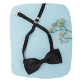 Black satin bow tie for boys with adjustable clip-on strap, displayed on a blue background with floral accent. Ideal for ages 1-5.