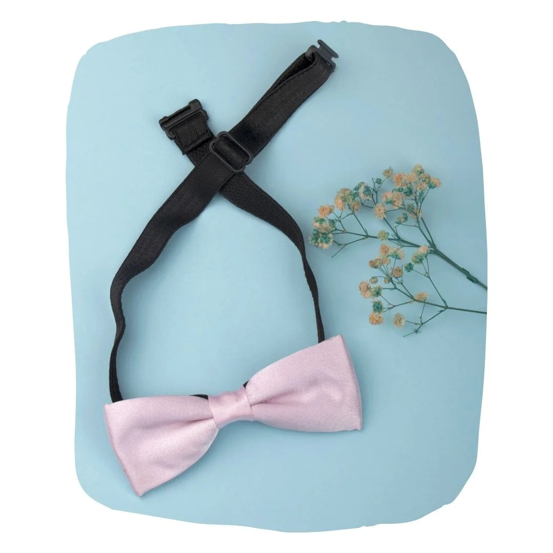 Adjustable satin bow tie for boys in baby pink with black clip-on strap, ideal for ages 1-5. Pre-tied design perfect for formal events or parties.