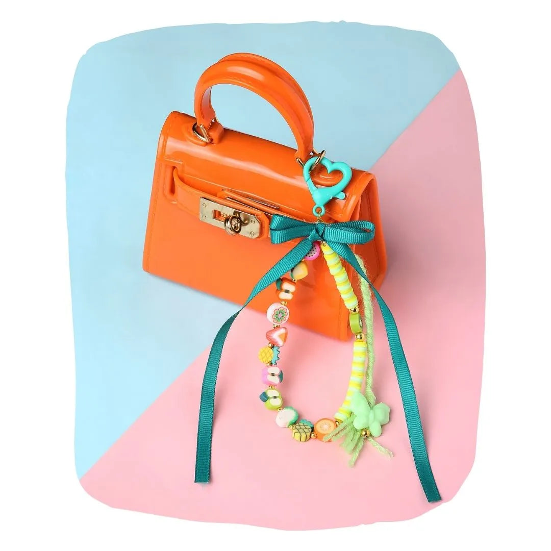 Fimo Bead Bag Charm - Green Ribbon Bow clipped to orange handbag; colorful beads and heart clip add playful style to kids' accessories.