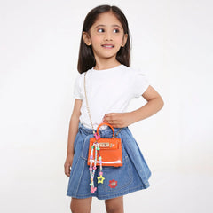 Young girl wearing denim skirt and white tee, carrying an orange mini bag with a Pink Multicolor Fimo Bead Charm attached.