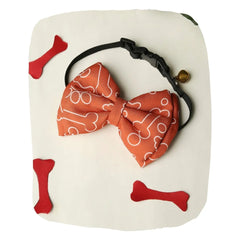 Adjustable orange satin dog bow tie with white paw print pattern and black strap, ideal for medium dogs in pet collars and ties category.