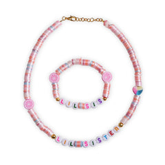 Flat lay of Arendelle Jewelry Set - Kids Personalized | Necklace & Bracelet with pastel pink beads and 'LIL SISTER' text, fun gift for girls.