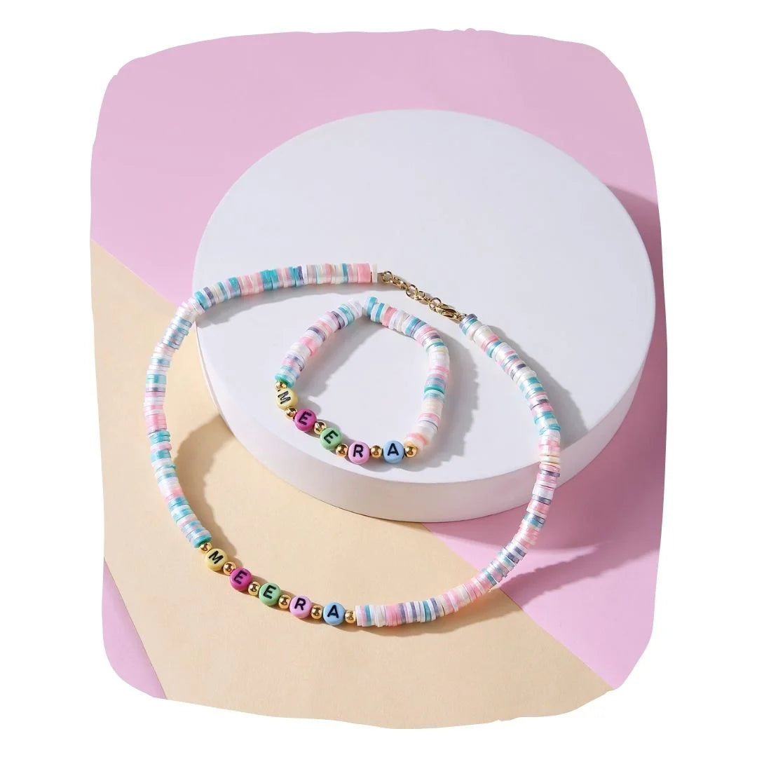 Kids custom name jewelry set with pastel bead necklace and bracelet, displayed on a white and pink background. Personalized gift for girls aged 7-12.