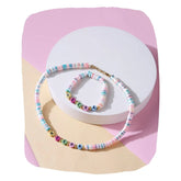 Kids custom name jewelry set with pastel bead necklace and bracelet, displayed on a white and pink background. Personalized gift for girls aged 7-12.