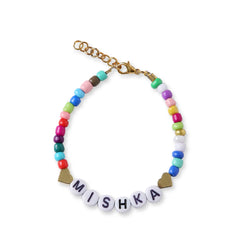 Close-up of personalized bracelet from Custom Name Jewelry - Kids Set, featuring colorful beads and name 'Mishka' with gold heart accents.