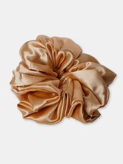 Close-up of a golden oversized silk satin scrunchie, offering a smooth, frizz-free hold for all hair types.