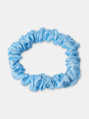 Close-up of a blue silk satin skinny scrunchie showing soft texture and gentle hold, ideal for reducing frizz and breakage.
