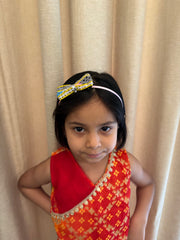 Stylish Navratri Hairband featuring handcrafted bow design in yellow and blue, worn by girl in traditional attire. Great for Garba celebrations.