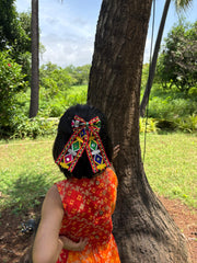 Traditional Navratri Pigtail Hair Bow worn by a girl in a red ethnic dress, showcasing festive flair and cultural charm for Garba nights.