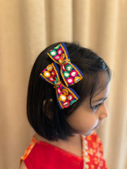 Girl wearing Dholida Bow Clip Set with vibrant mirror work and tassels, perfect for Navratri Garba celebrations and festive outfits.
