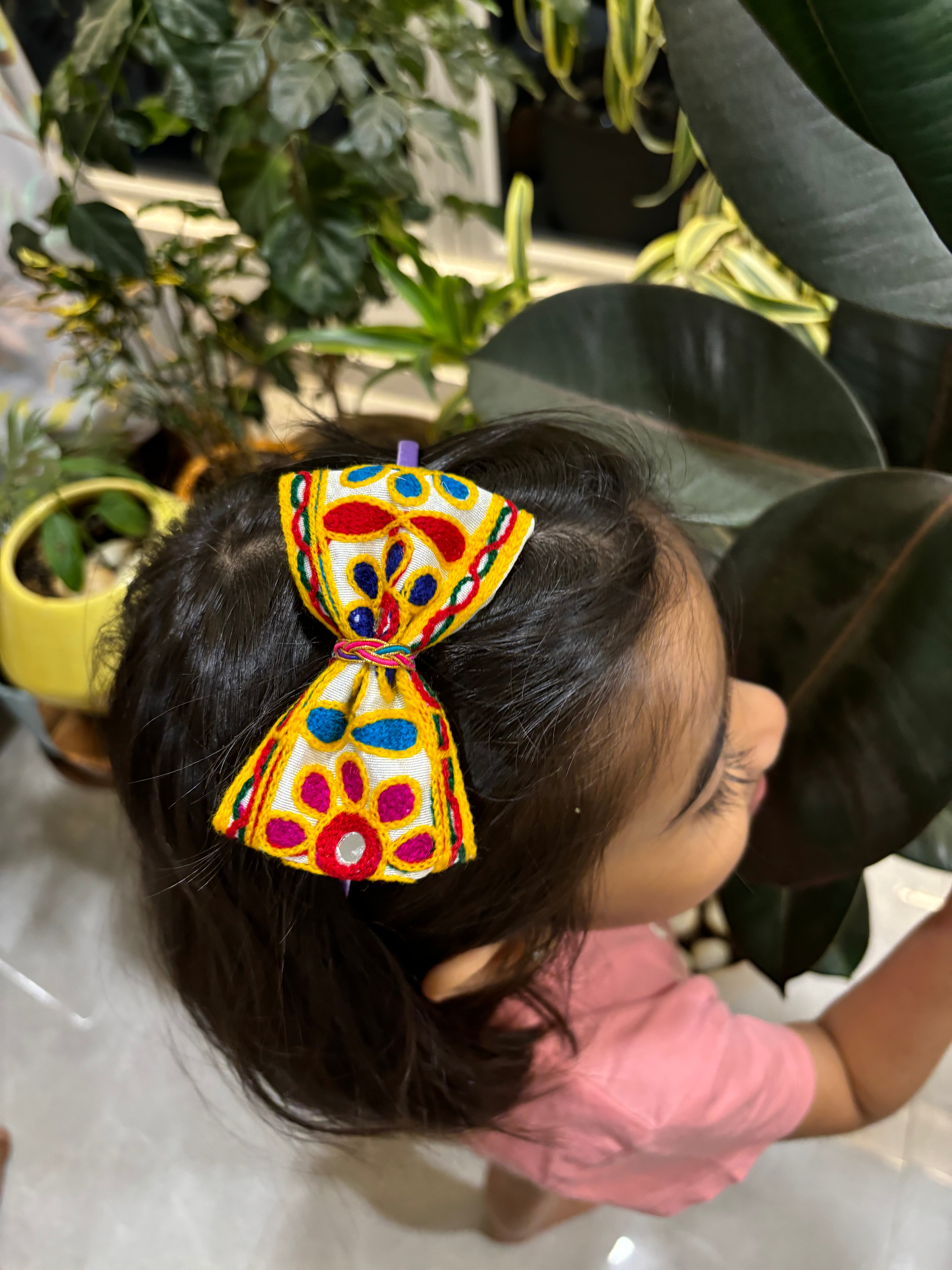 Kesariyo Hairband with mirror work, tassels, and beads styled on a girl's hair, perfect for Navratri Garba and festive traditional outfits.