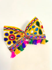 Close-up of Kesariyo Tassel Bow with mirror work and bright tassels, ideal Navratri hair pin for girls' festive outfits.
