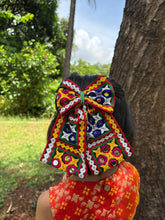 Chogada Pigtail Bow for girls styled in hair, featuring vibrant mirror work and embroidery, perfect for Navratri Garba celebrations.