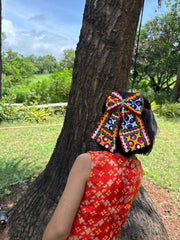 Colorful Chogada Pigtail Bow worn by a girl in festive attire, ideal for enhancing traditional Navratri looks with playful charm.