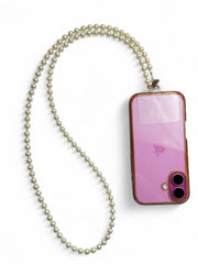 White pearl phone sling attached to a pink phone case, ideal for enhancing Navratri and Garba looks with elegance.