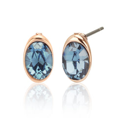 Close-up of Swarovski blue crystal stud earrings with rose gold setting. Part of a colorful and elegant pendant and earrings jewelry set.