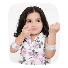 Young girl wearing silver metal bangles from the Traditional Metal Bangles Set - 36 Pcs, styled with a floral outfit for a festive look.