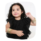 Young girl wearing Gold Metal Bangles Set - Traditional Jewelry in 12 colors, styled with a black ruffled dress. Ethnic bangles for kids' fashion.