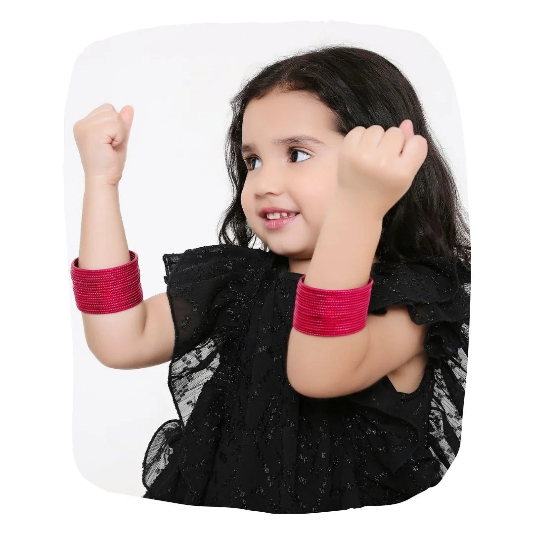Young girl wearing Arendelle's Pink Metal Bangles Set - Traditional Metal Bangles | 36 Pcs, showcasing vibrant and elegant jewelry for kids.