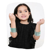 Young girl wearing Arendelle Kids mint green metal bangles set of 36, perfect for festive occasions and stylish outfits.