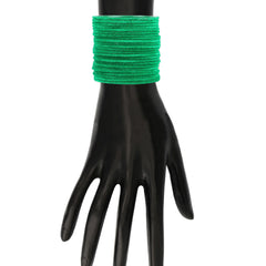 Emerald green velvet bangles set of 48 worn on a mannequin hand, showcasing the vibrant color and soft texture. Ideal for festive and daily wear.