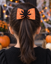 Itsy Spider orange glitter spider hair bow on a girl's ponytail