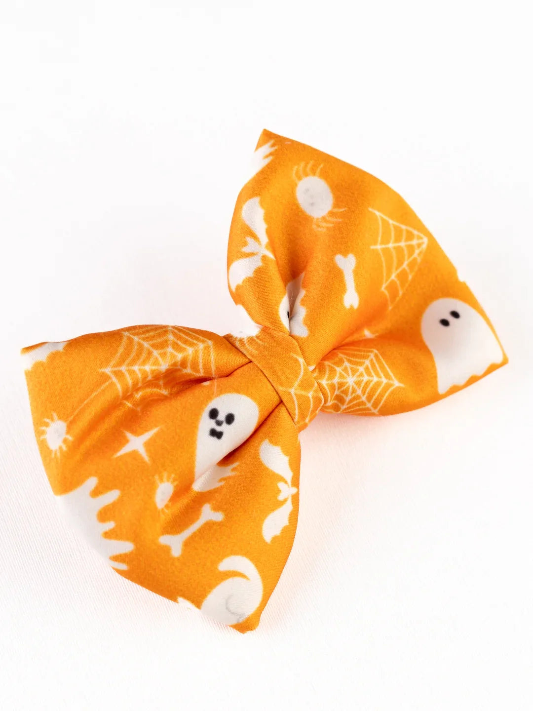 Side view of Orange Halloween Hair Bow with white Halloween icons