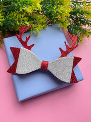 Christmas Glitter Hair Bow with red antlers and silver sparkle placed on gift box, a trending holiday accessory for girls aged 3 to 12.