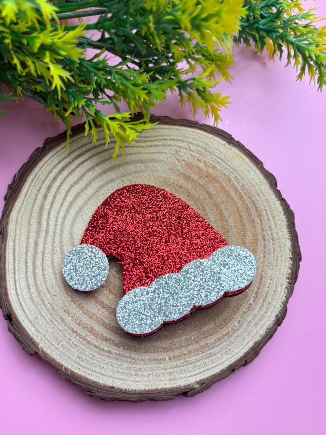 Christmas Glitter Hair Clip shaped like a Santa hat displayed on a wooden base, ideal for holiday-themed accessories for girls.