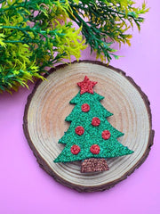 Christmas Glitter Hair Clip styled on a wooden display with pink background, highlighting its vibrant holiday design and texture.