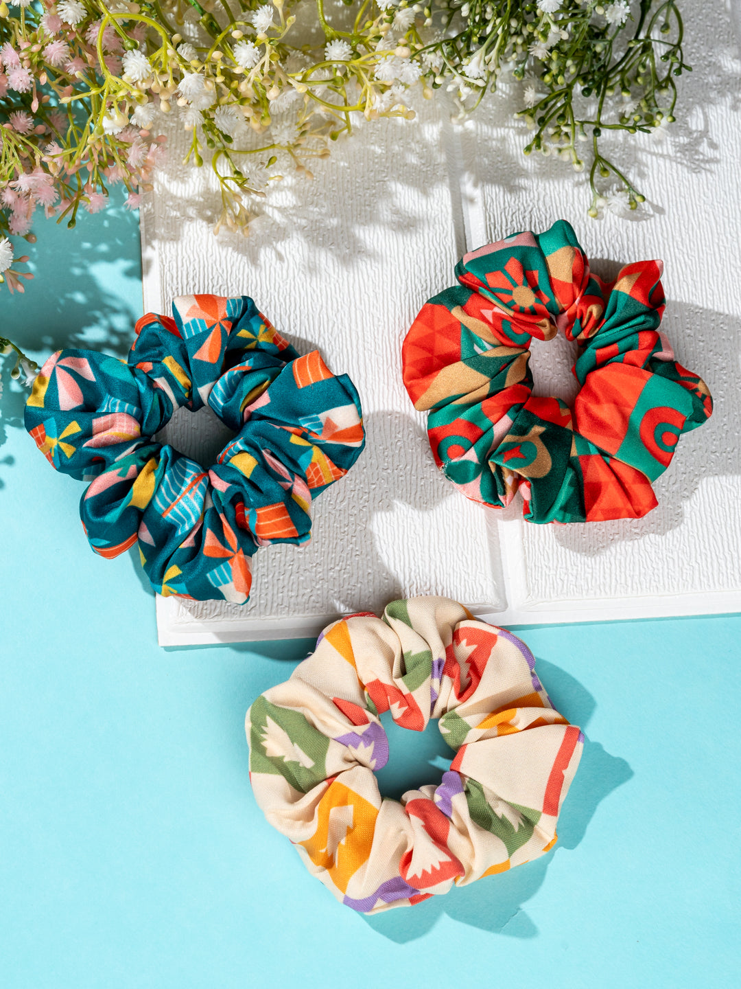 Three colorful holiday scrunchies in festive prints from the Christmas Glitter Hair Accessories collection, displayed on a bright background.