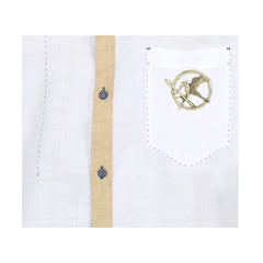Gold Mockingjay brooch pin displayed on decorative surface