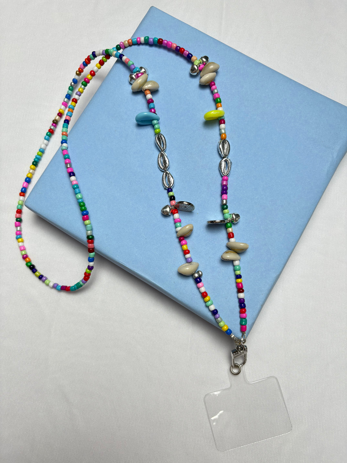 Arendelle Phone Sling - Navratri Special with colorful beads and shells, displayed on a blue box. Ideal for festive traditional outfits.