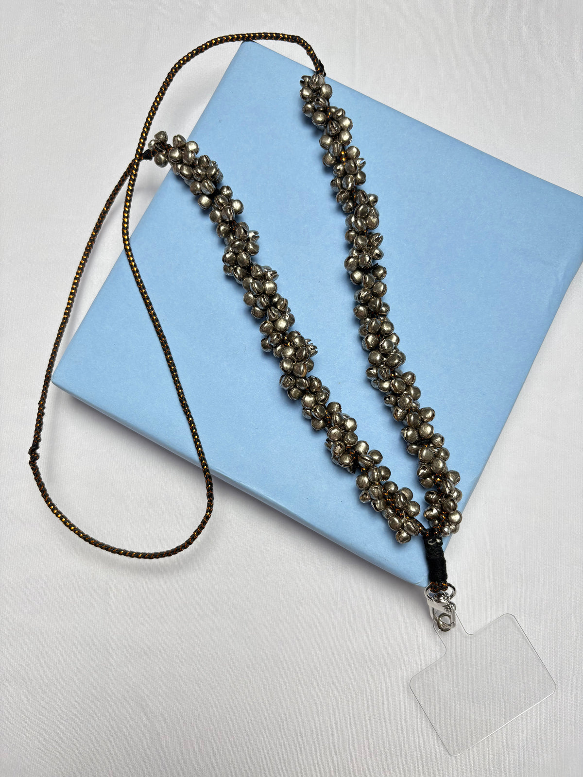 Arendelle Navratri Phone Sling with ghungroo beads displayed on a blue box. Ideal festive accessory for traditional outfits.