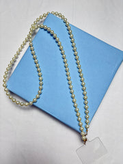 Navratri Pearl Phone Sling with white pearls displayed on a blue gift box, perfect for festive traditional outfits.