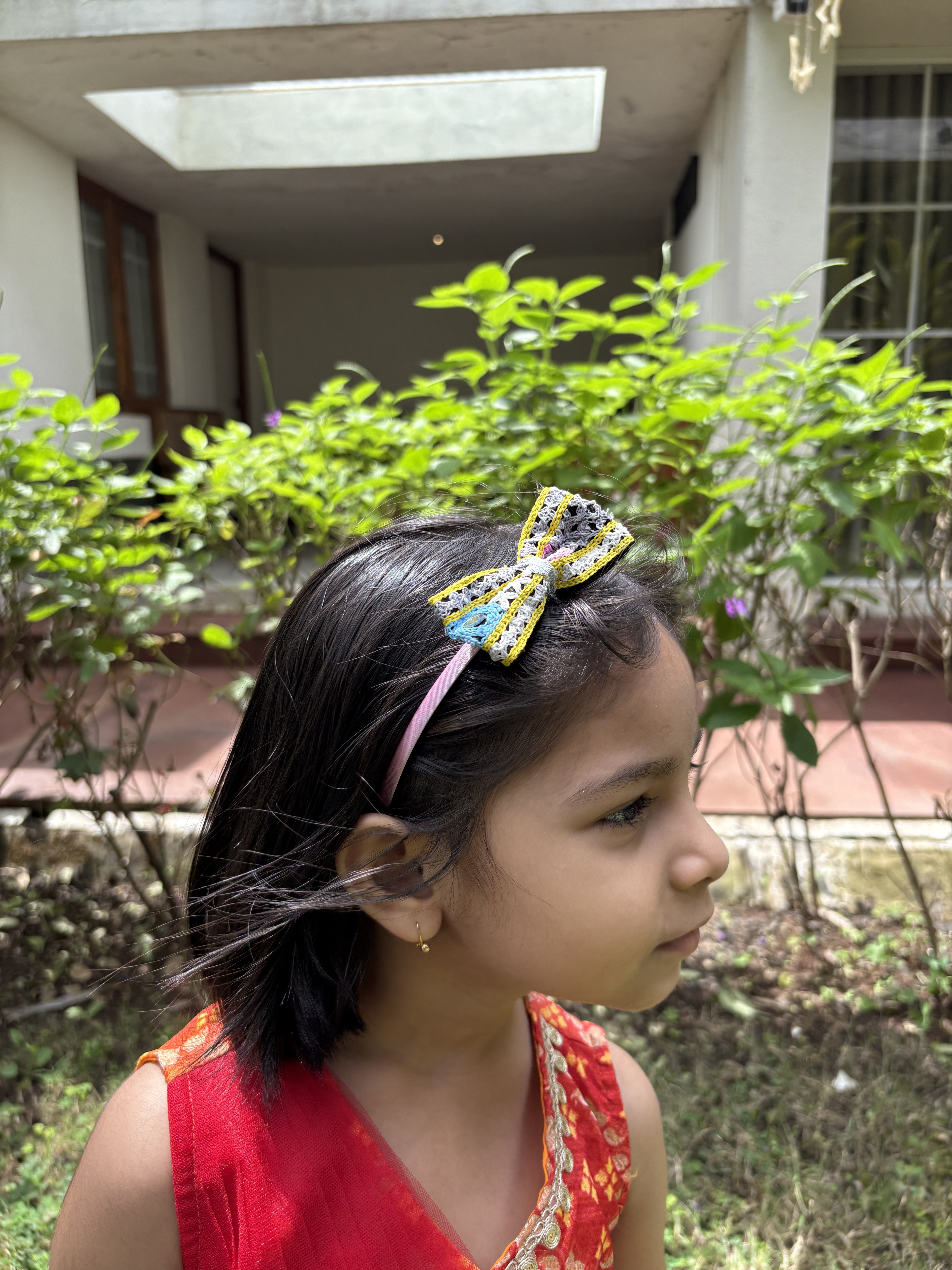 Side view of girl in festive dress wearing Pari Hoon Main Hairband, a stylish Navratri accessory with mirror work and tassels. Perfect for celebrations.
