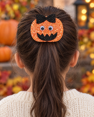Jack-o'-Bow orange glitter pumpkin hair clip on a girl's ponytail