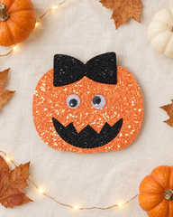 Jack-o'-Bow Halloween hair clip flat lay with mini pumpkins